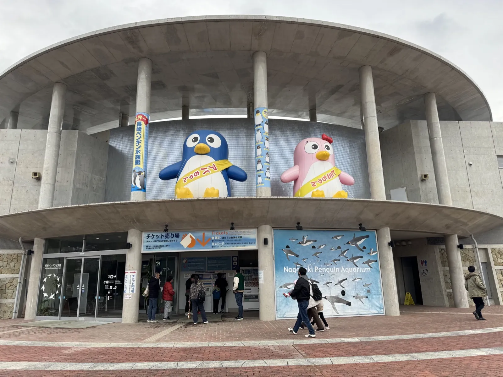 長崎企鵝水族館入口外觀,售票處上方有藍色與粉紅色企鵝吉祥物